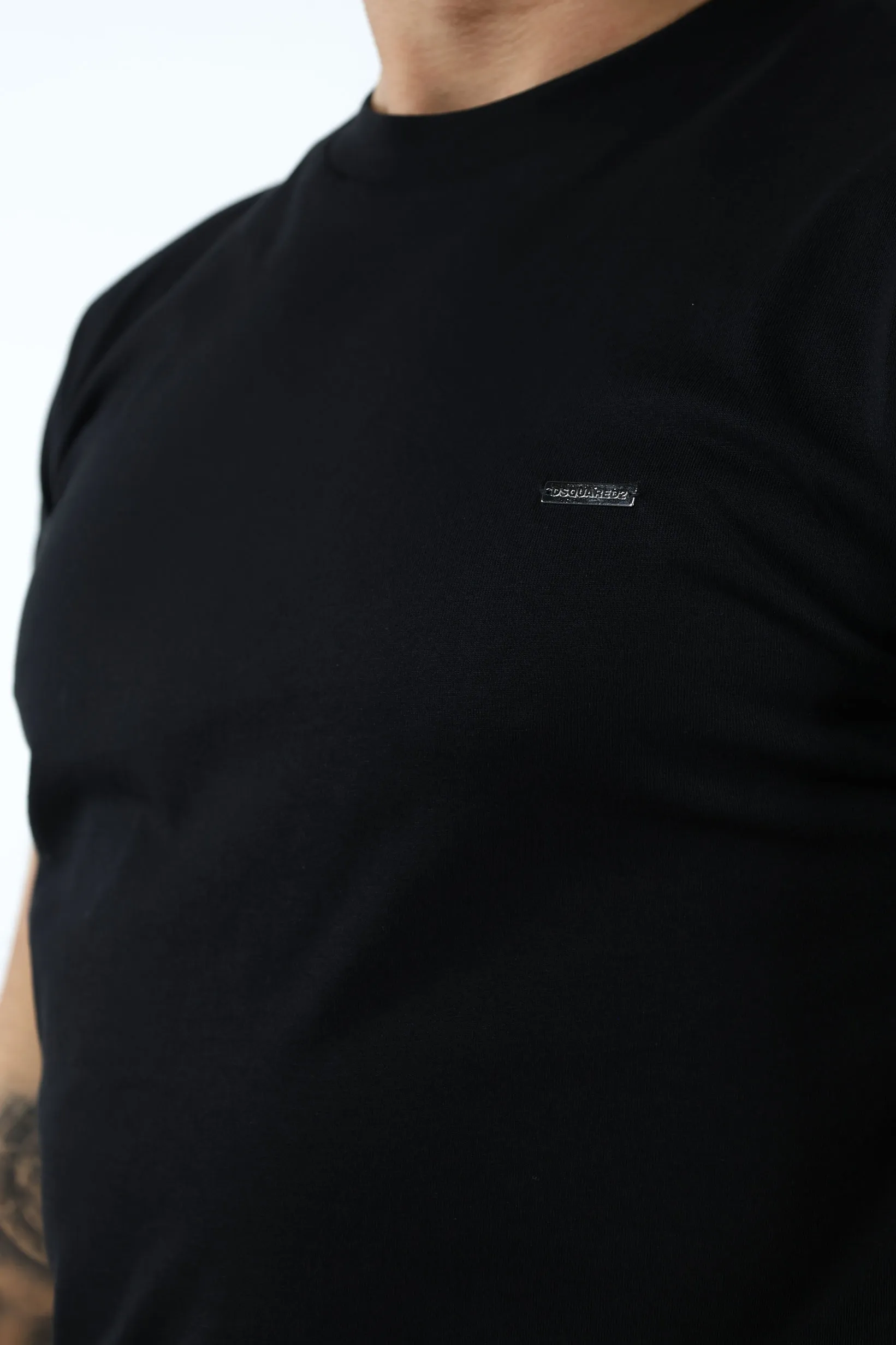 Camiseta negra con logo en placa pequeña